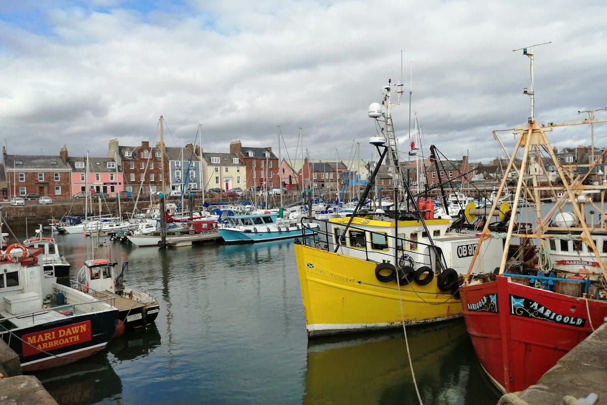 Crail's historic harbour with colourful boats and stone buildings